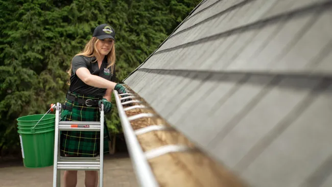 a person cleaning gutters by hand